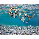 Authentic trading beads, sculpted recycled glass, coconut shell, cowrie shells, brass, and gold for the tiniest of detail.