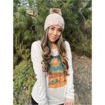 A generous faux fur pom-pom looks like real fur, on a colorful chunky knit hat.