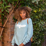 Attractive woman with light blue, long-sleeved sweatshirt that has a graphic of a soaring bird with the words "FREE SPIRIT" across its wings.